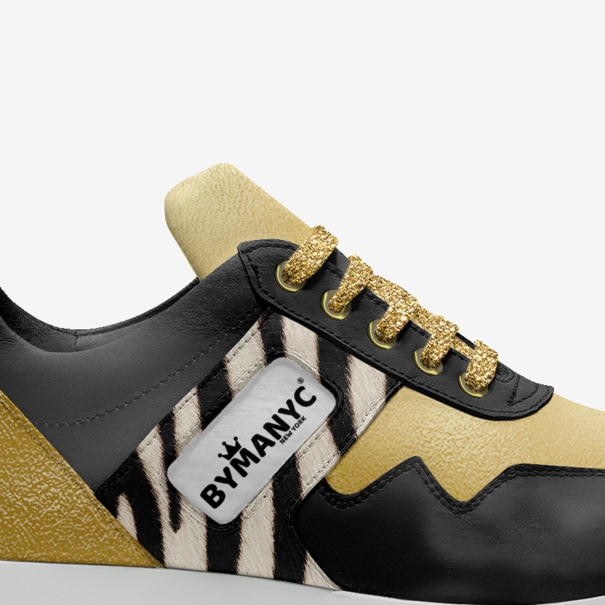 Sneaker with zebra pattern and gold accents, featuring the BYMANYC logo.