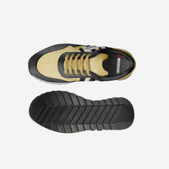 Sneaker with gold and black design on a light gray background