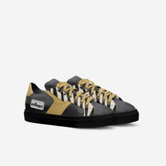Black and gold sneaker with striped pattern on a white background