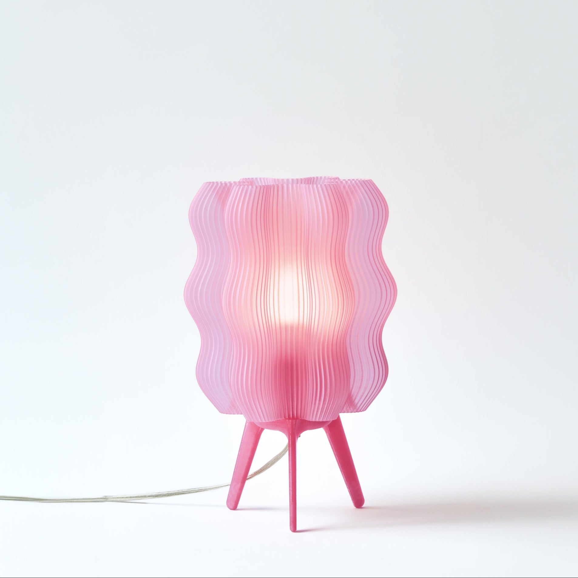 Pink table lamp with wavy design on a white background