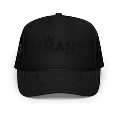 Black trucker cap with 'BY MANN' branding on a white background
