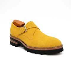 Yellow suede shoe with brown sole on a white background