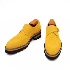Pair of yellow loafers on a white background