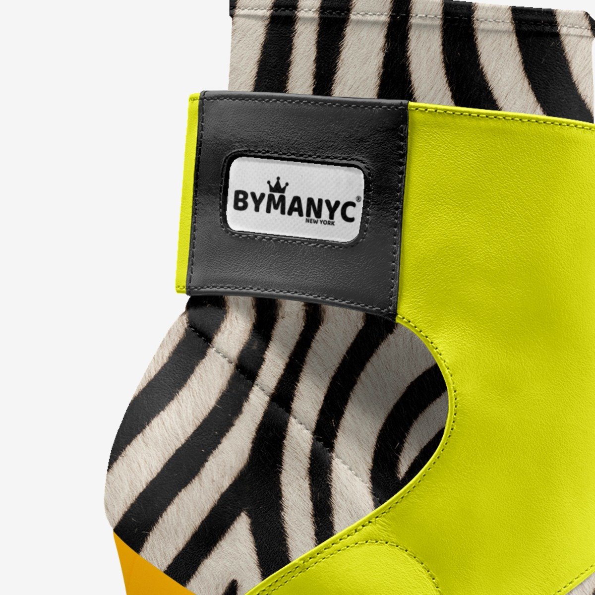 Yellow and zebra-patterned shoe with ByManyc label on a white background