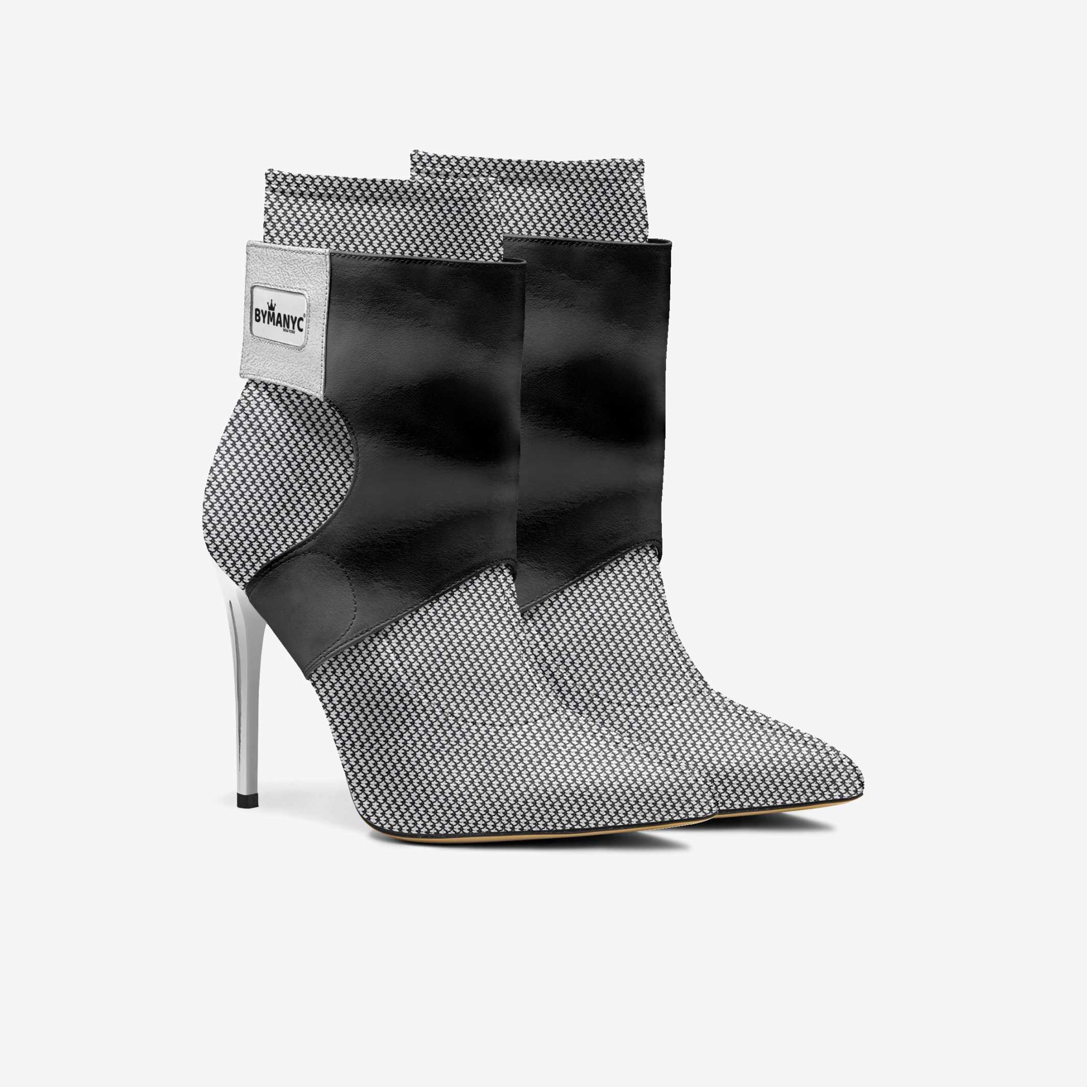 Black and white patterned high-heeled ankle boots with a brand label on a light gray background