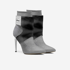 Black and white patterned high-heeled ankle boots with a brand label on a light gray background