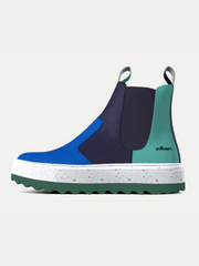 Blue and green Chelsea boot with a white sole on a light gray background