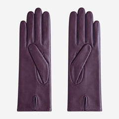 Pair of purple leather gloves on a light gray background
