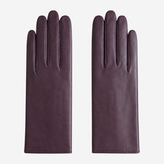 Pair of dark purple leather gloves on a white background