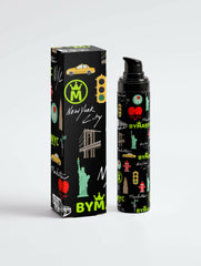 Black cosmetic bottle and packaging with New York City-themed design on a white background