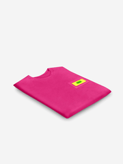 Pink t-shirt with a small yellow label on a light gray background