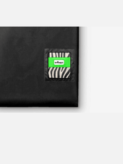 Black pouch with a zebra patterned patch and a green label on a white background