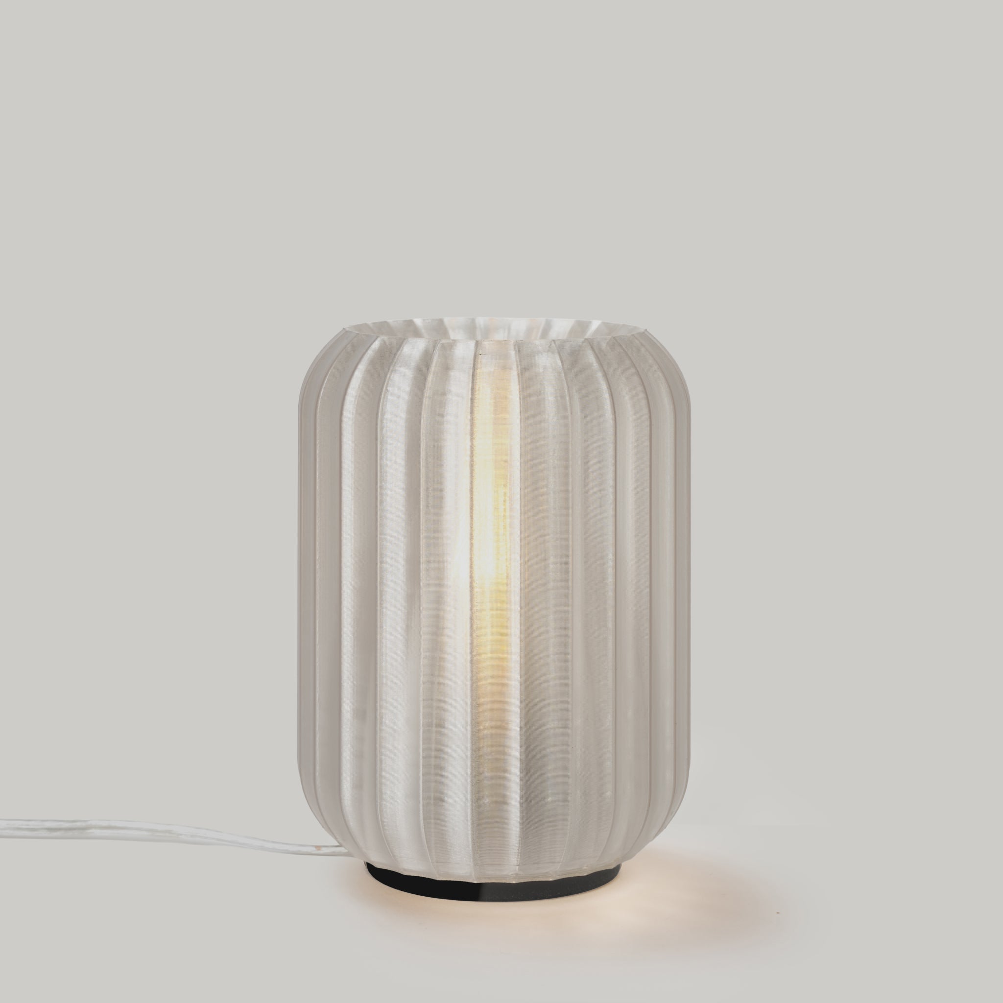Decorative table lamp with ribbed design on a plain background