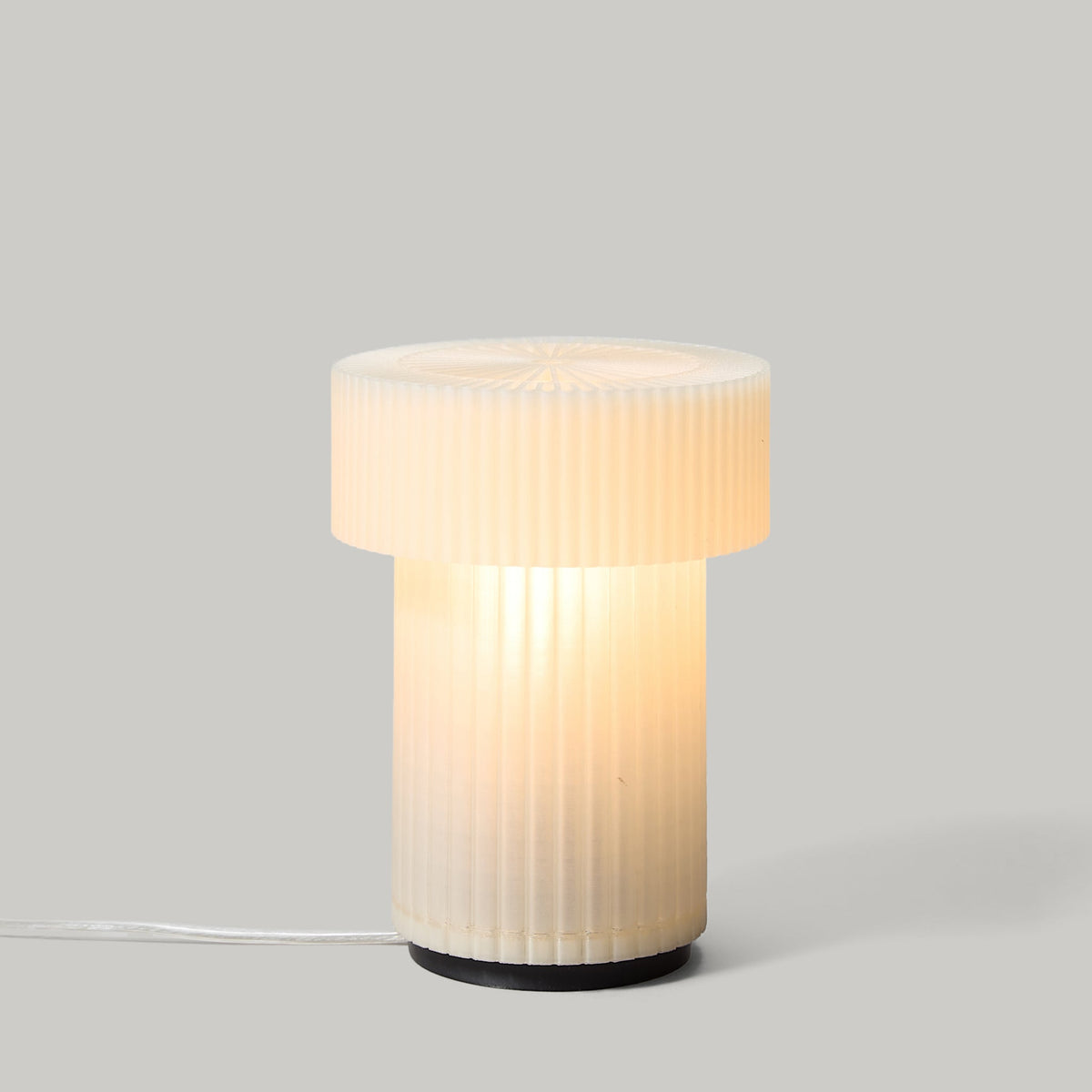 Table lamp with ribbed design on a gray background
