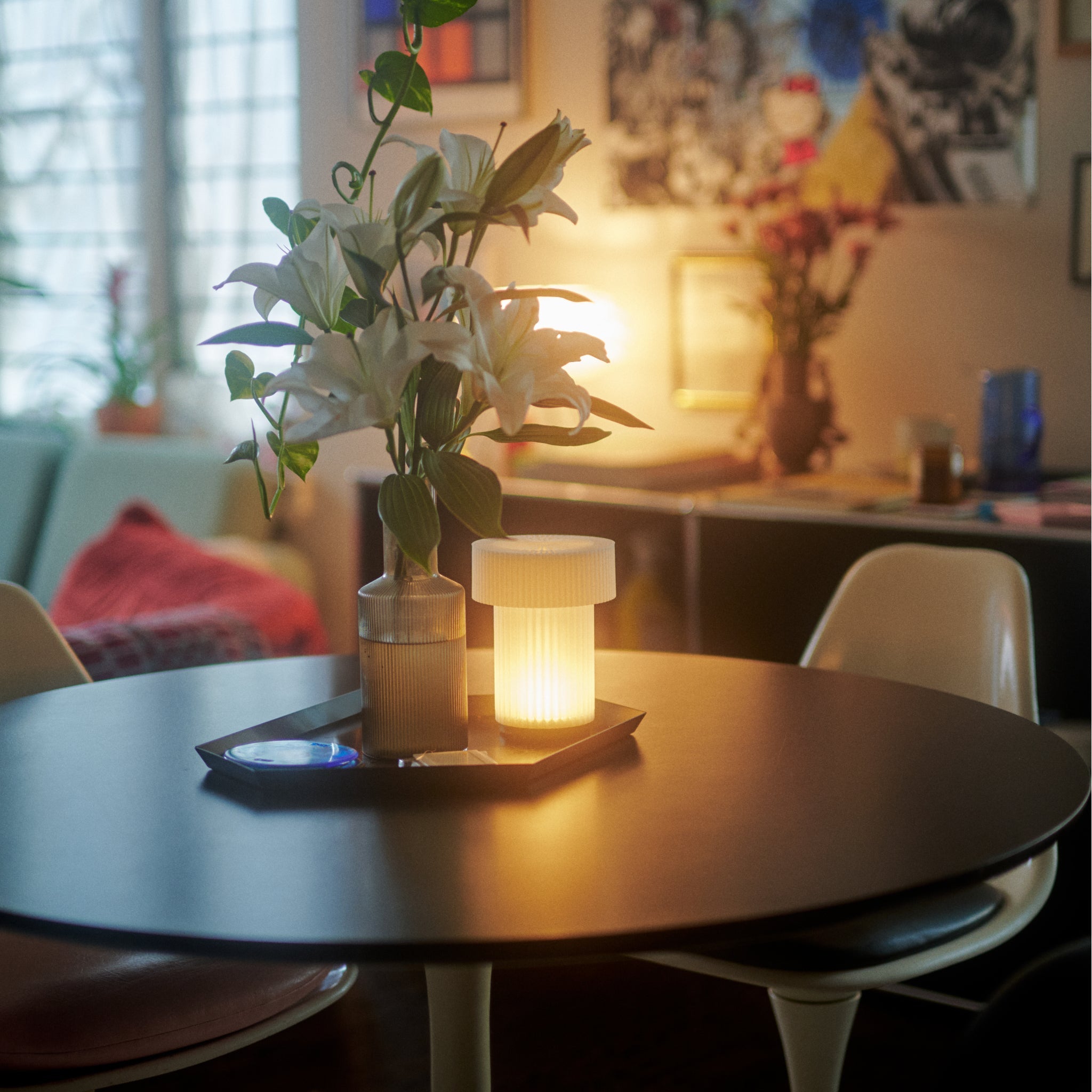 Round table with a lit candle and plant in a cozy indoor setting