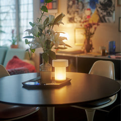 Round table with a lit candle and plant in a cozy indoor setting