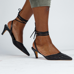 Black and brown high-heeled shoes with pointed toes on a white background