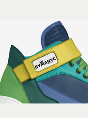 Colorful sneaker with a yellow strap displaying 'BYMANYC' on a white background