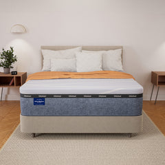 Bed with a mattress on a wooden floor in a bedroom setting