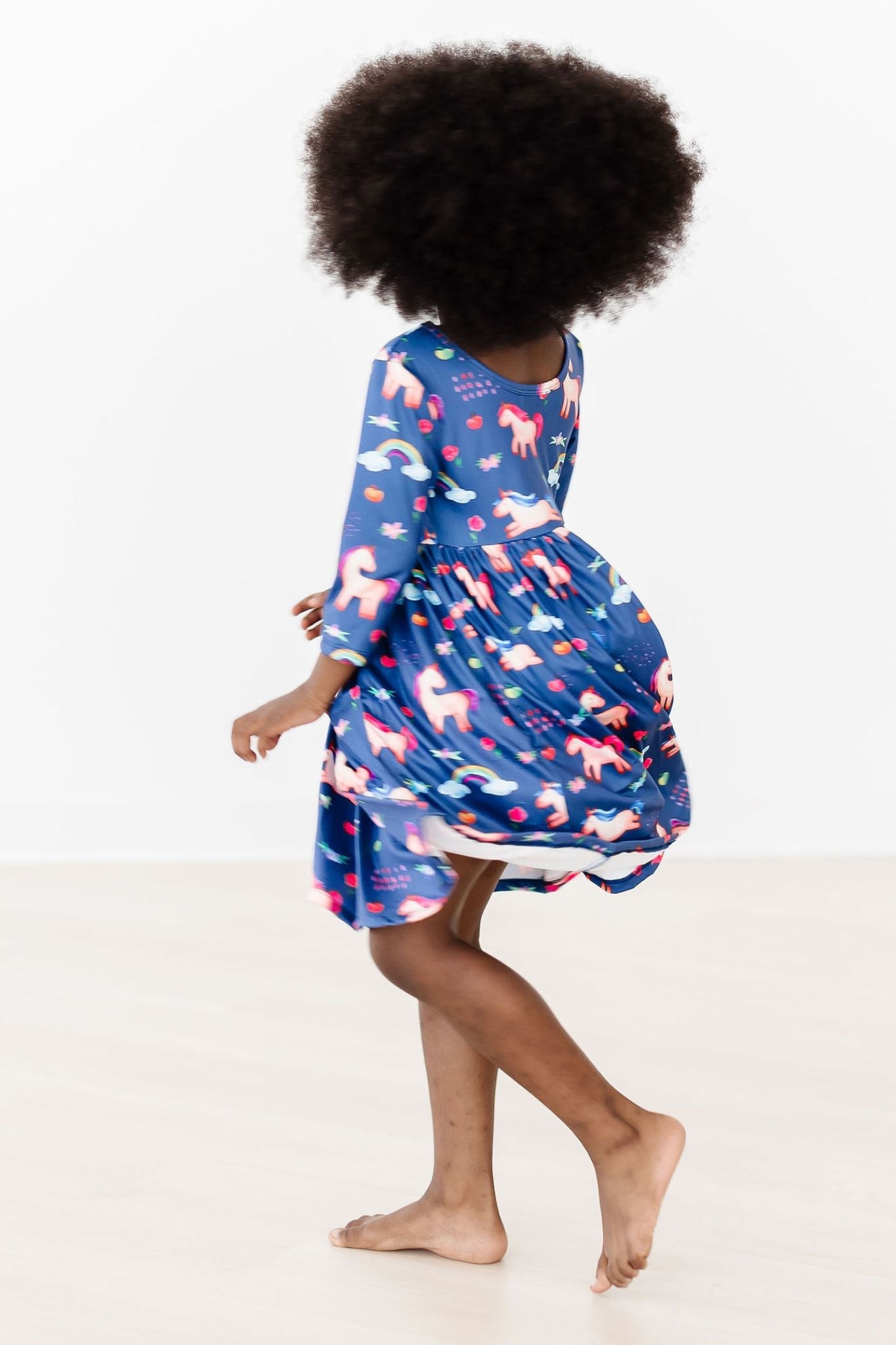 Person wearing a blue dress with pink floral patterns on a white background