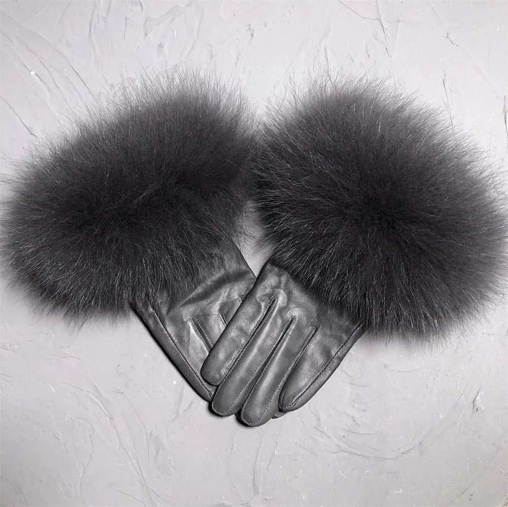 Pair of gray leather gloves with fluffy fur cuffs on a light gray background