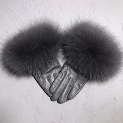 Pair of gray leather gloves with fluffy fur cuffs on a light gray background