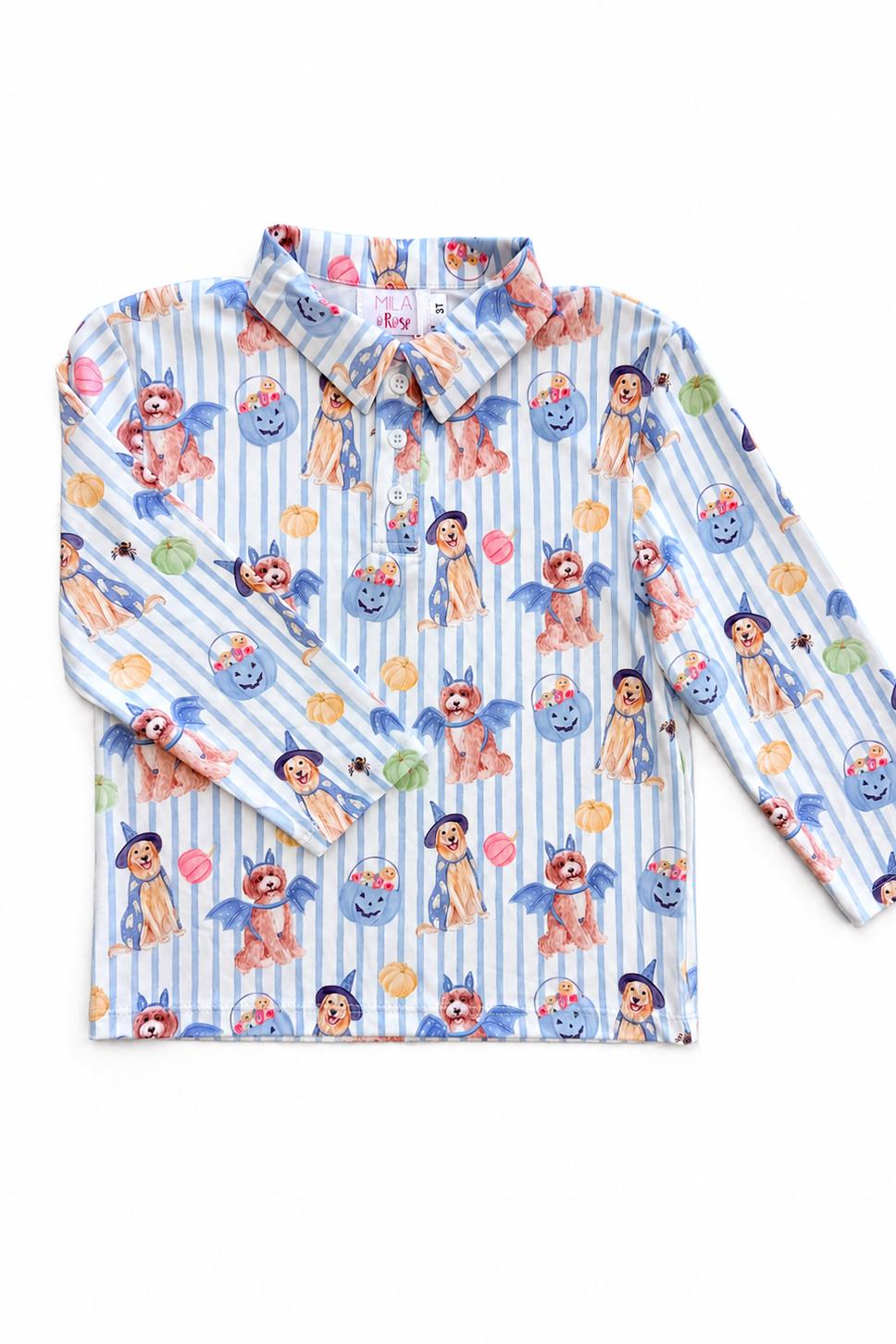 A long-sleeve button-up shirt with a playful cartoon print featuring characters resembling Pocahontas and blue-haired figures, set against a light blue and white striped background.