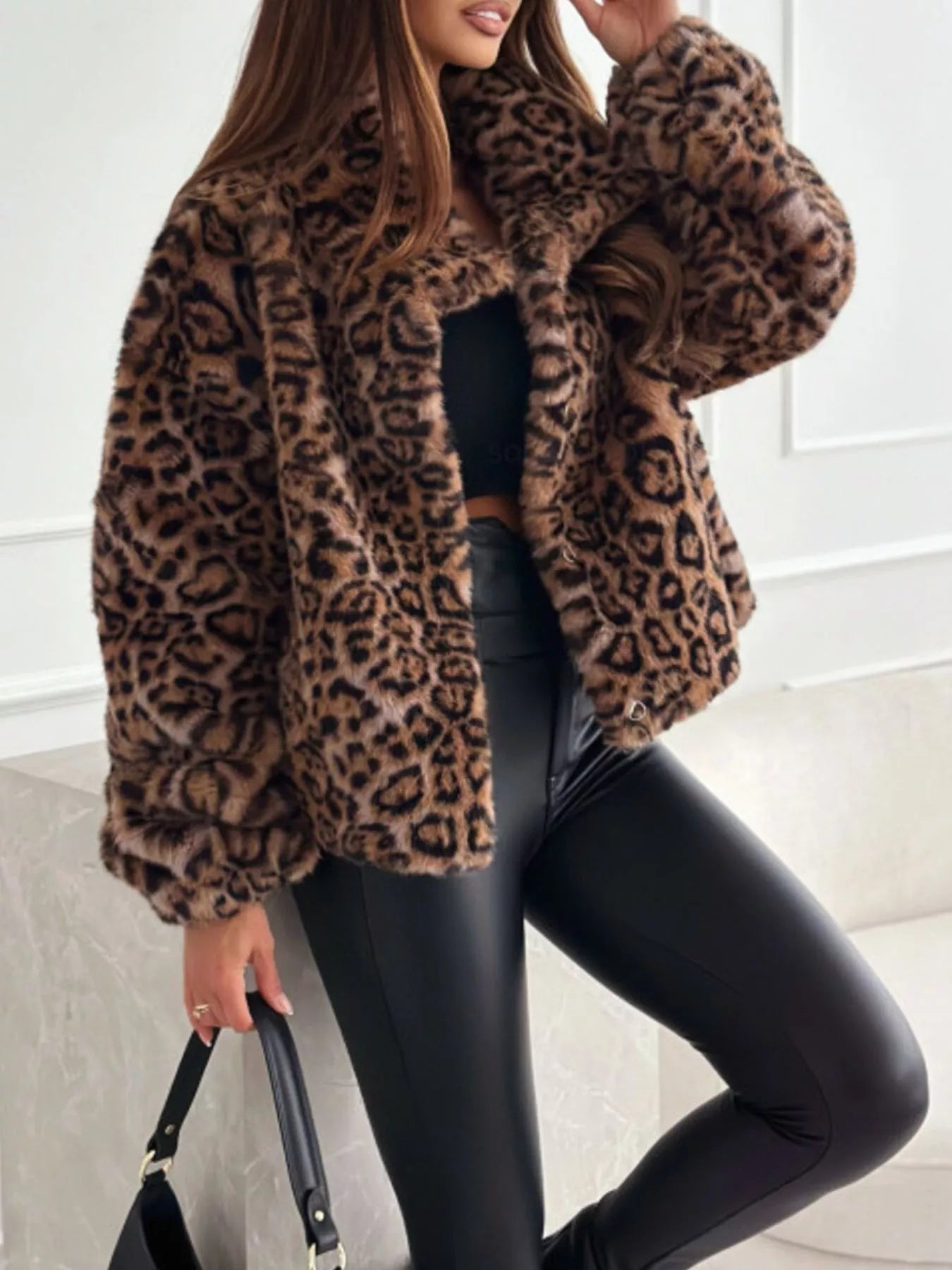 Person wearing a leopard print coat in an indoor setting