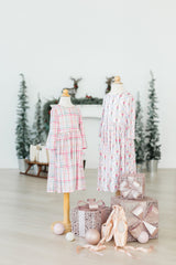 Two mannequins wearing dresses with decorative eggs and gift boxes on a light background
