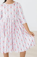 White dress with colorful pattern worn by a person on a white background
