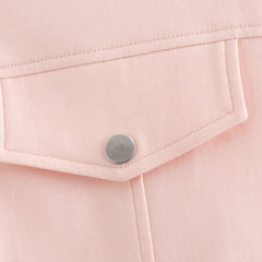 Close-up of a pink fabric pocket with a button on a light pink background