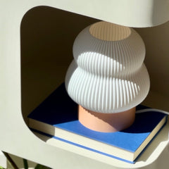 White textured lamp on a blue book with a white base