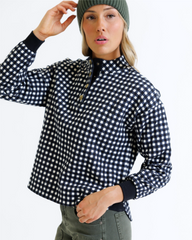 Person wearing a black and white checkered shirt with a plain background