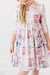 Young girl wearing a dress with pink dog pattern on a white background