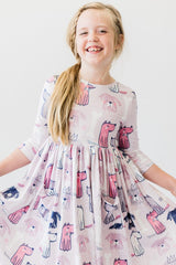 Young girl wearing a dress with dog pattern on a white background