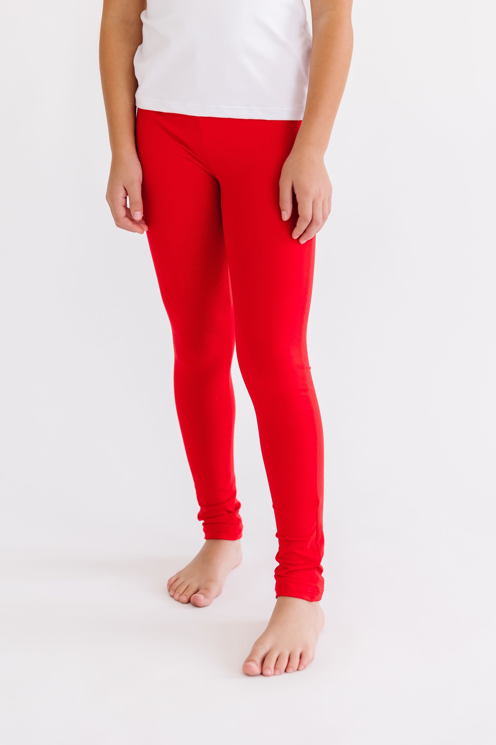 Person wearing red leggings and a white top on a white background