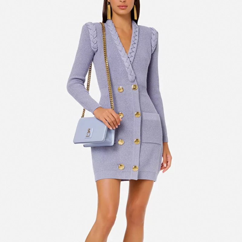Woman wearing a light blue dress with gold buttons holding a matching handbag on a white background