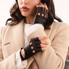 Woman wearing black leather gloves with a beige coat