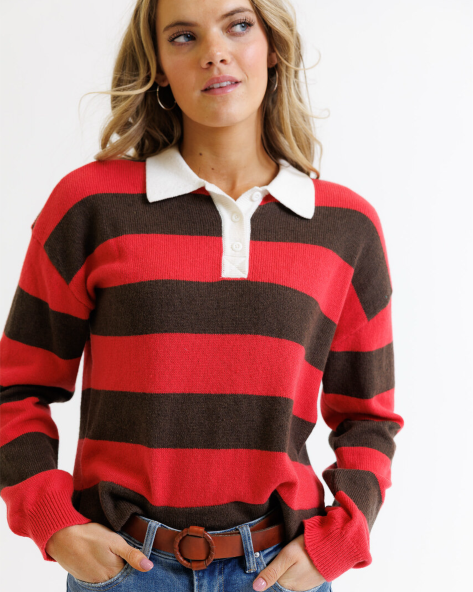 Woman wearing a red and brown striped sweater with a white collar.