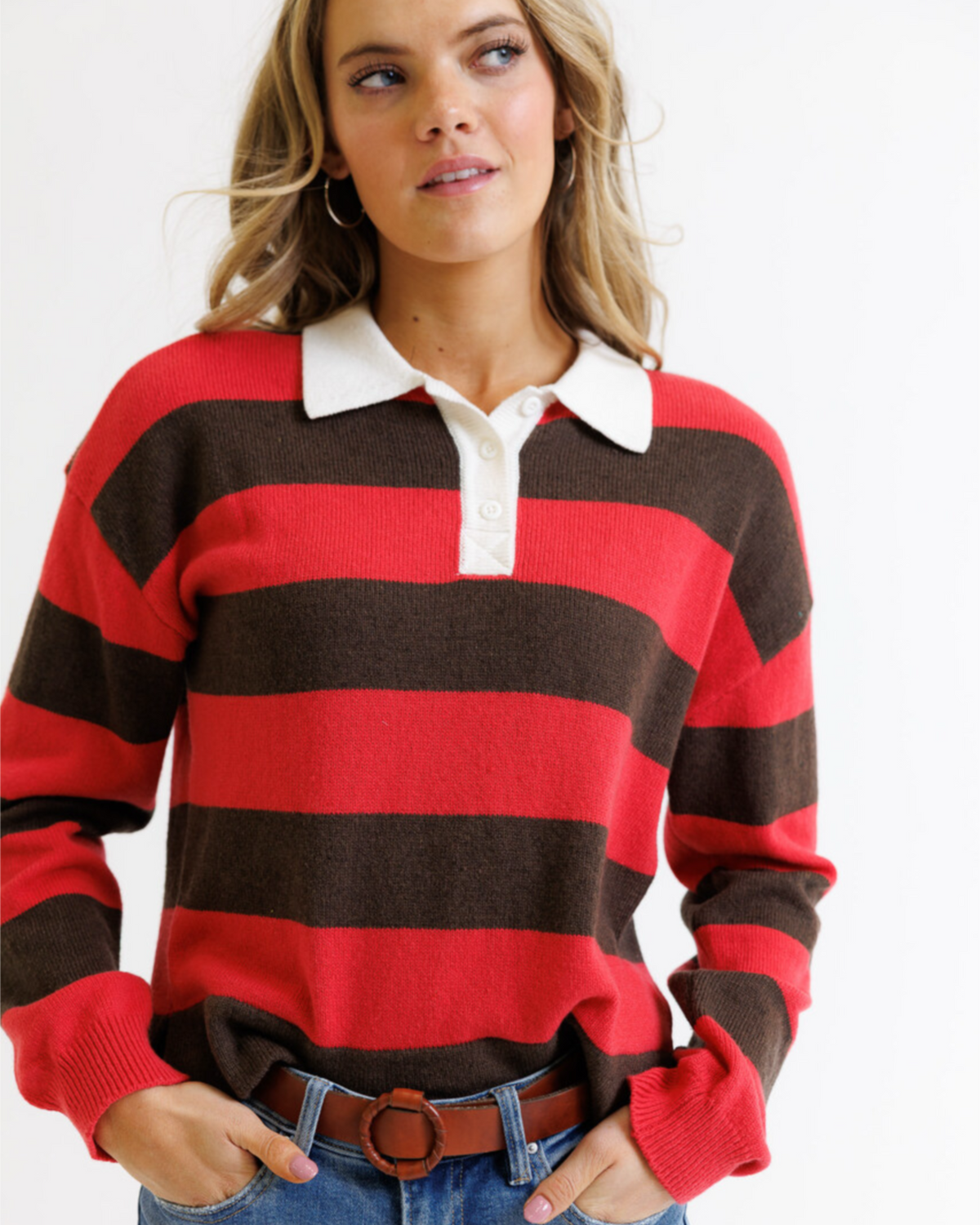 Woman wearing a red and brown striped sweater with a white collar.