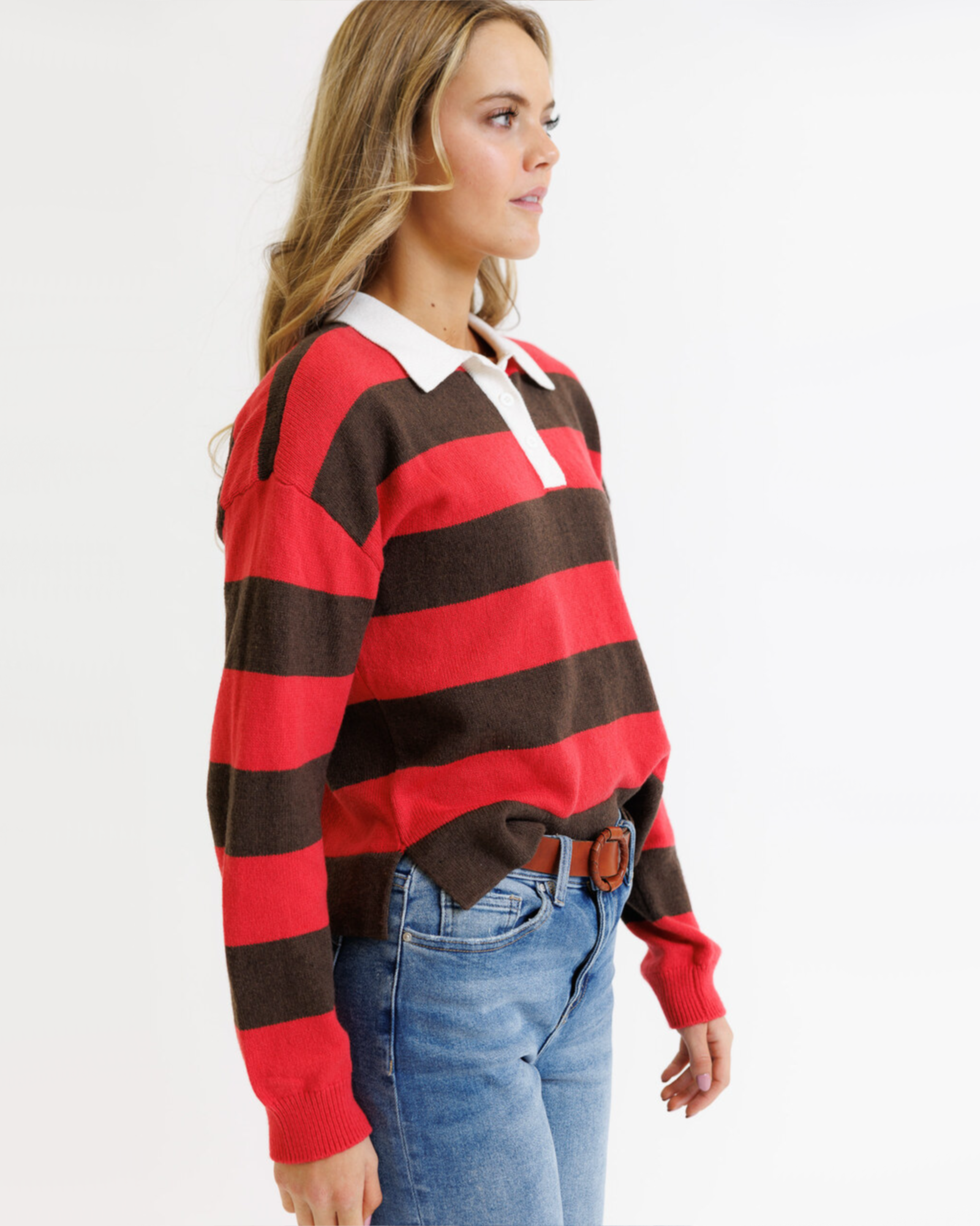 Woman wearing a red and brown striped sweater with a white collar on a white background