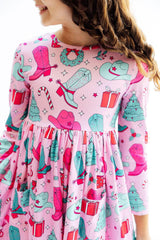 Child wearing a pink dress with festive pattern on a white background