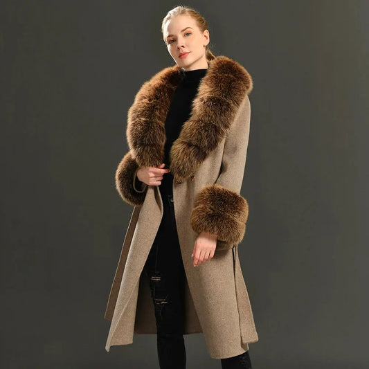 Woman wearing a long beige coat with brown fur trim on a dark background