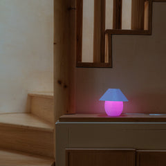 Small pink lamp on a wooden surface with a mirror in the background