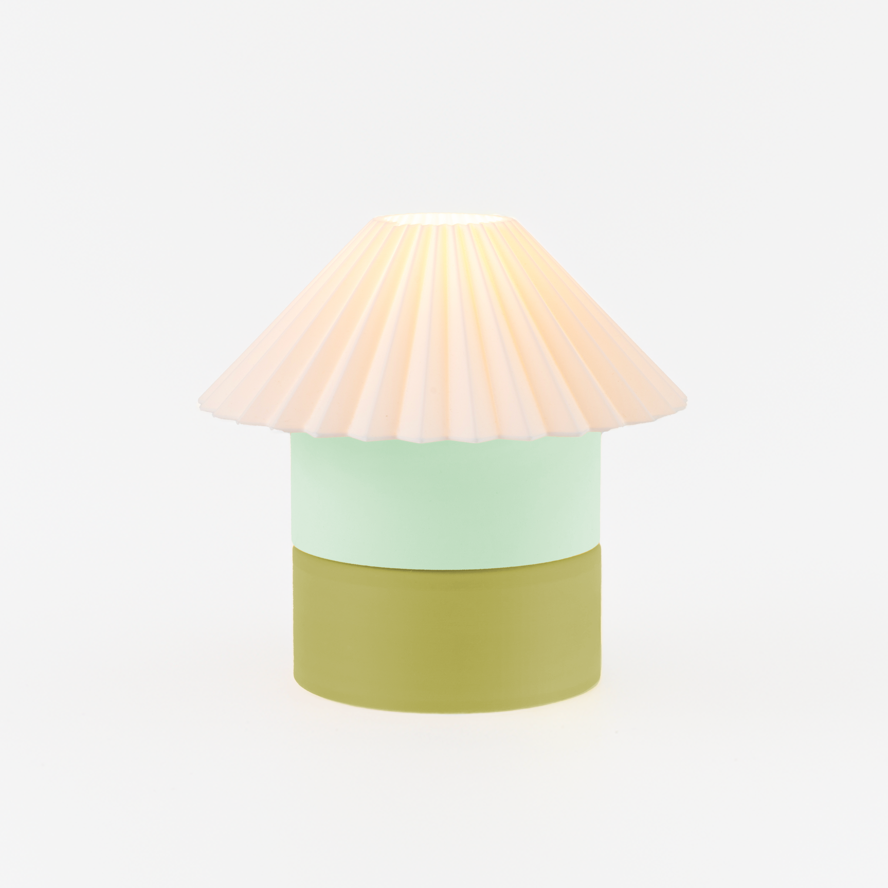 Table lamp with a pastel pink shade, light green middle section, and green base on a white background