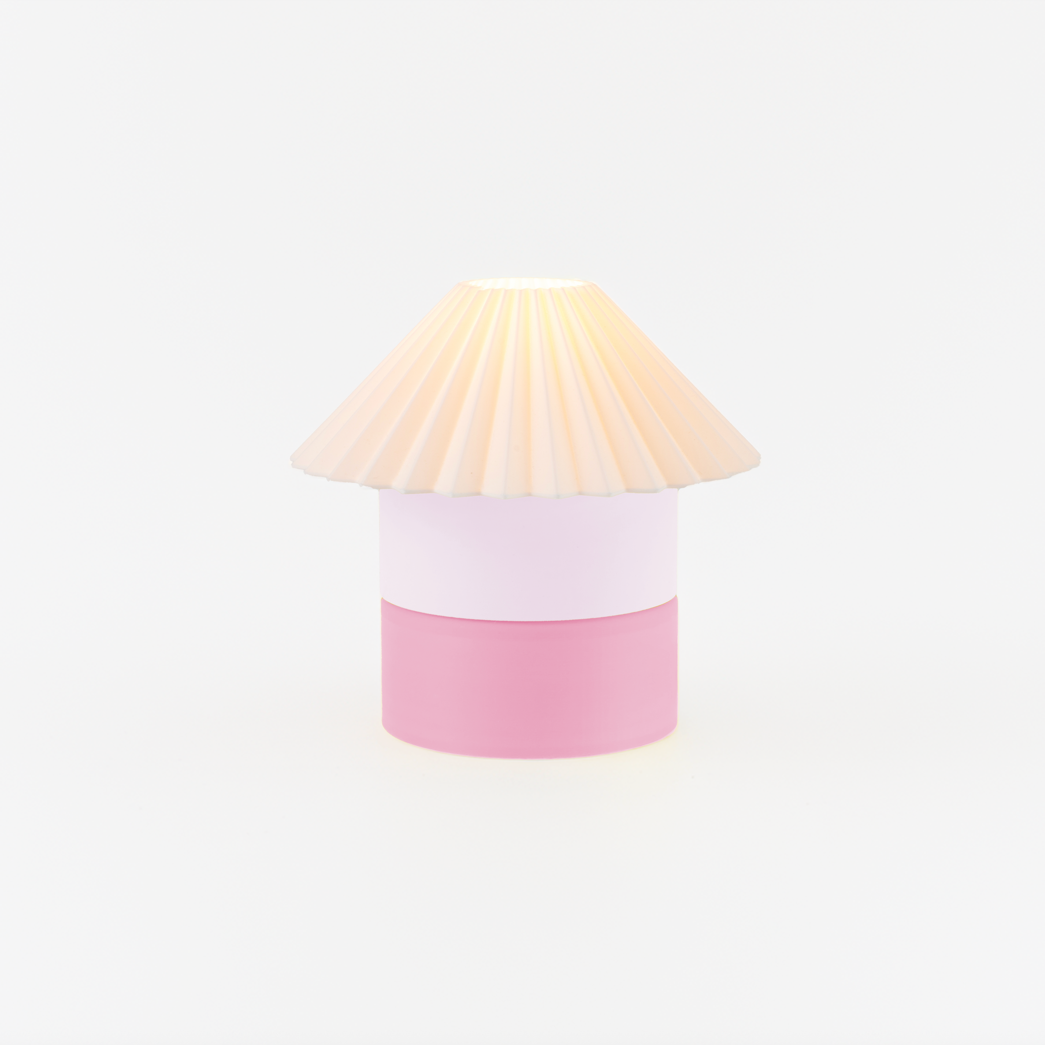 Lamp with a pink base and beige shade on a white background