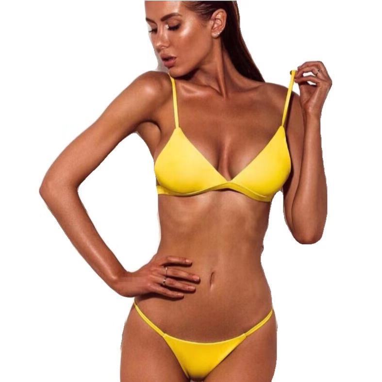 Woman wearing a yellow bikini against a white background