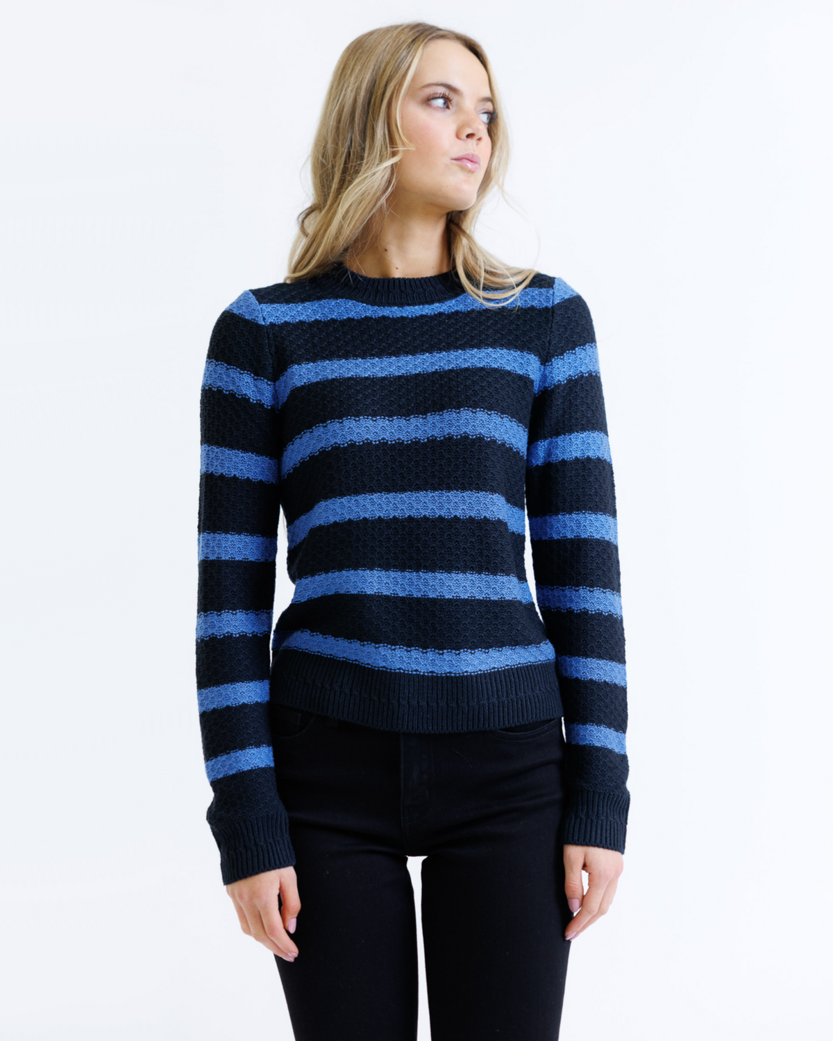 Woman wearing a black and blue striped sweater on a white background