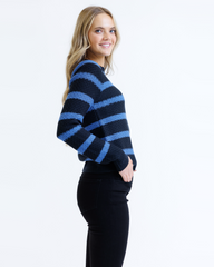Woman wearing a black and blue striped sweater on a white background