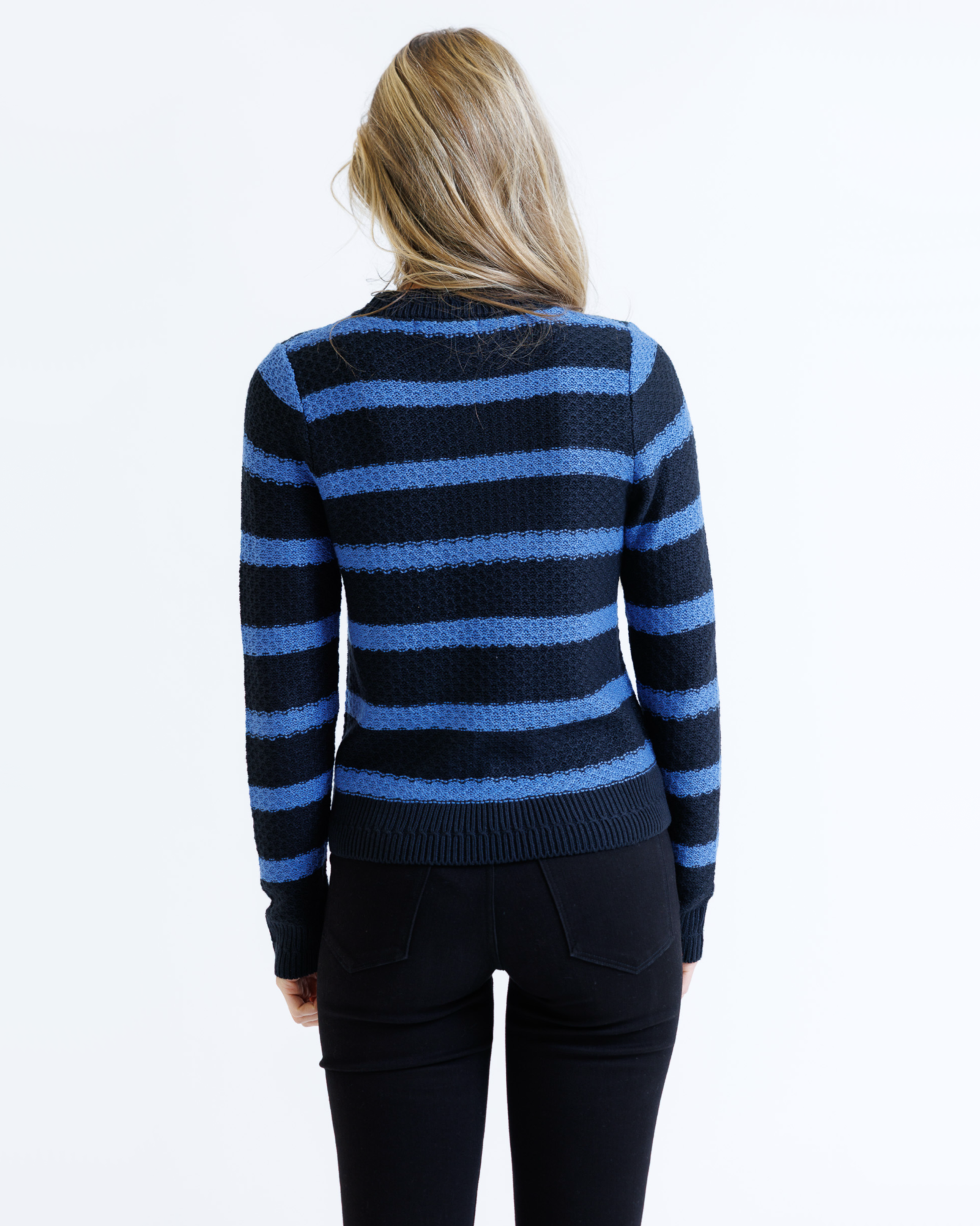 Person wearing a black and blue striped sweater on a white background